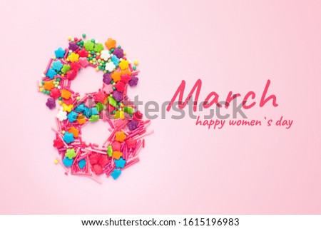 Number 8 on a pink background in the form of confectionery sprinkles. Number 8 in the shape of sweets. March 8 International Women's Day pink background with greeting text, flat lay