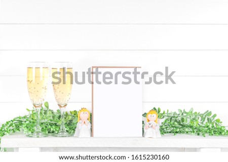 Wedding or Christmas invitation layout, invitation card with stalks of greenery and glasses of champagne on a light background for your design