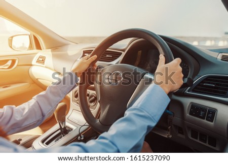 Business women drive car on the road in the city. Hands control car steering wheel
