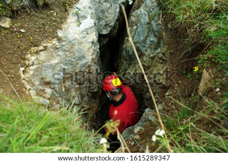 Caver descends in a cave. Spelunking is an extreme sport Royalty-Free Stock Photo #1615289347