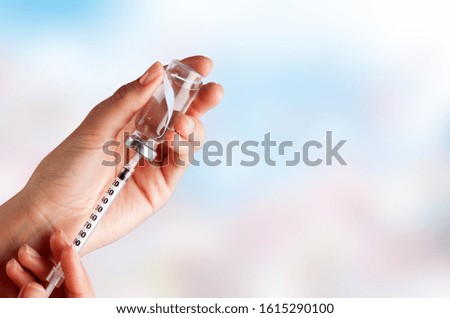 Human Hands with injection Syringe, on blurred background.