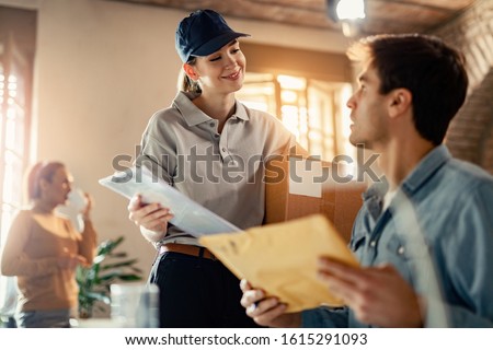 Happy delivery woman communicating with entrepreneur while delivering him package in the office.