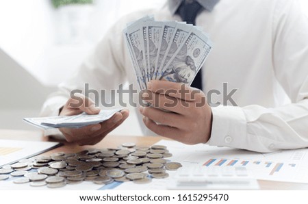 Hands of businessman are holding large amounts of money to prepare and distribute to employees to participate in the financial success of the company, Give money concept