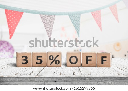 Special price 35 percent off promotion sign on a desk with colorful flags above