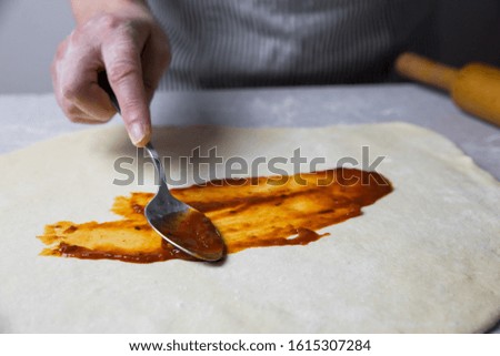 Chef Spreading Tomato On Pizza
