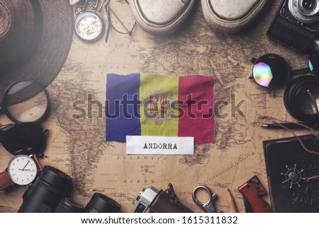 Andorra Flag Between Traveler's Accessories on Old Vintage Map. Overhead Shot