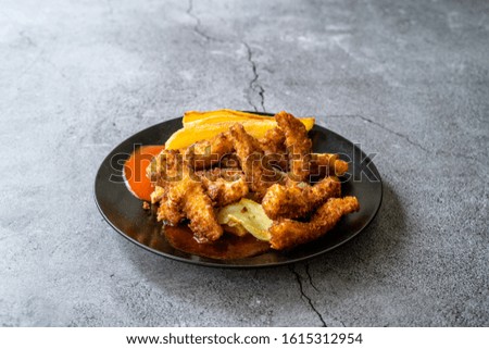 Fish and Chips made with Breaded and Fried Seabass in Black Plate.