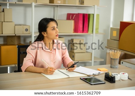 Work from home, SME Young woman working owner on online shopping store taking order from customer on mobile phone and thinking.