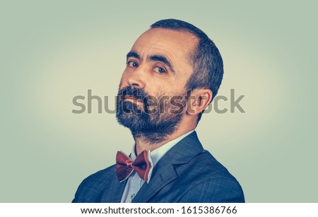 Closeup portrait of mature man with beard in side profile looking at you camera conceited, vainglorious, self-glorious. Mixed race bearded model isolated on green yellow background with copy space Royalty-Free Stock Photo #1615386766