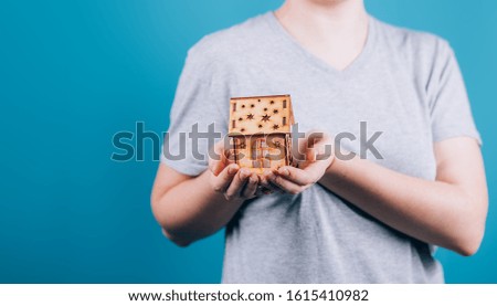 closeup picture of woman hands holding small wooden house