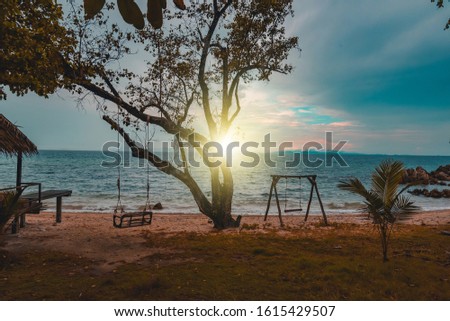 Vintage and retro toning of tropical beach with blue sky and clear sea which including of a wooden umbrella and chair in sunrise time with vintage retro tone. Vacation time as concept.