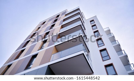 Contemporary residential building exterior in the daylight. Modern apartment buildings on a sunny day with a blue sky. Facade of a modern apartment building Royalty-Free Stock Photo #1615448542