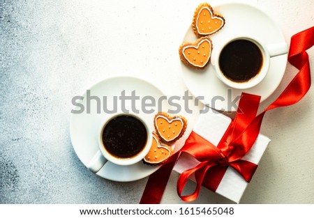 St. Valentine card concept with heart shaped cookies and cup of coffee on stone white background with copy space