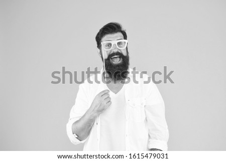 Bearded man happy to join party. Guy with beard and mustache hold eyeglasses photo booth prop. Party accessory. Good mood. Holiday celebration. Smart nerd eyeglasses. Last minute costume party ideas.