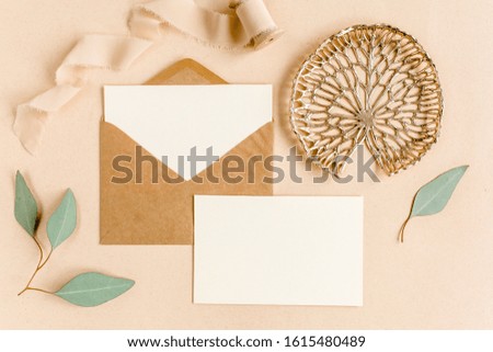 Mockup wedding invitation, blank greeting card and craft envelope, green leaves eucalyptus. Flat lay, top view.