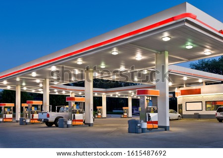 Horizontal shot of a retail gasoline station and convenience store at dusk. Royalty-Free Stock Photo #1615487692