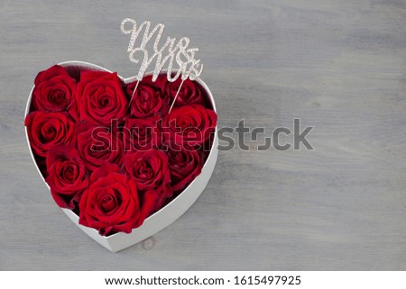 in a box in the shape of a heart are buds of red roses, and the letters decor are Mr. and Mrs.