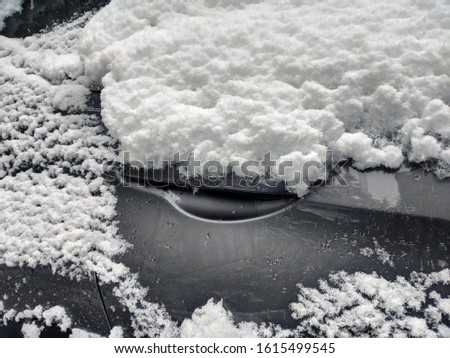 Focus on a snowy, ice covered car door handle after a pacific northwest snowstorm