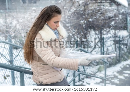 Young woman with umbrella in snowfall