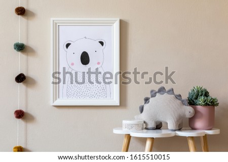 Stylish scandinavian nursery interior with mock up photo frame, plush dino, design furniture, toys and accessories. Beautiful decoration on the beige background wall. Home decor for children room.