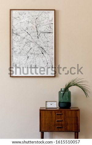 Modern scandinavian living room interior with mock up poster frame, design retro commode, tropical leaf in vase, gold clock and elegant accessories. Beige wall. Japandi. Template. Stylish home decor. 