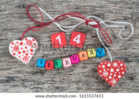 February cube calendar and hearts on wooden background for valentines day