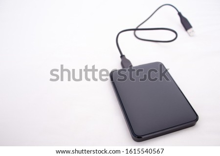 external hard drive connected to the USB cable out of focus and white background