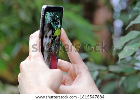 A young woman takes a self-portrait with her smartphone. A selfie with her mobile phone