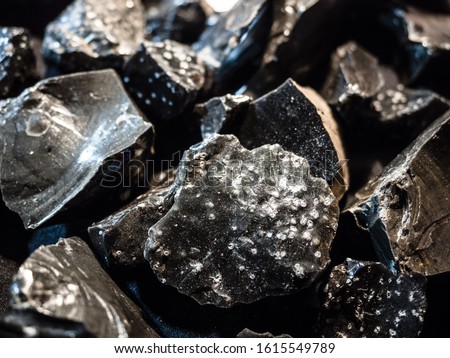Background formed by pieces of graphite extracted from a mine. Royalty-Free Stock Photo #1615549789