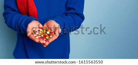 Boy caught a cold and uses pills to heal. Studio on Cyan background