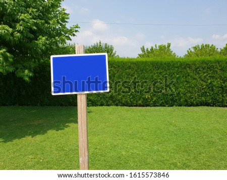 Post with clean sign, with space to write, in the middle of nature. Horizontal image with a green domain. Template to print written concepts about nature, parks, natural spaces. Mockup. Clean.