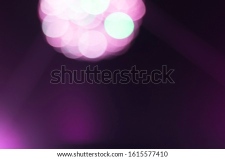 Defocused shining disco ball in futuristic colours: white, purple and blue. Blurry bokeh neon lights background for design