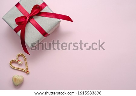 zero waste concept. environmentally friendly wooden, wicker hearts and gift with ribbon on a pink background. Congratulations on Valentine's Day, birthday or other holiday. horizontal orientation
