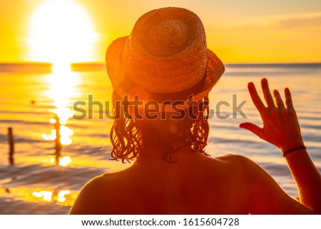 A young girl with a hat on a sunset in Roatan. Honduras