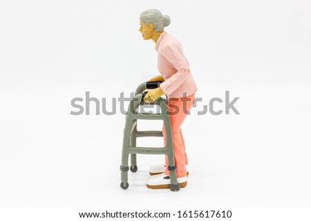 Isolated Disabled Elderly Woman Using a Zimmerframe. Disability Toy Concept. Inclusive and Equal Opportunity Toy. - Photography