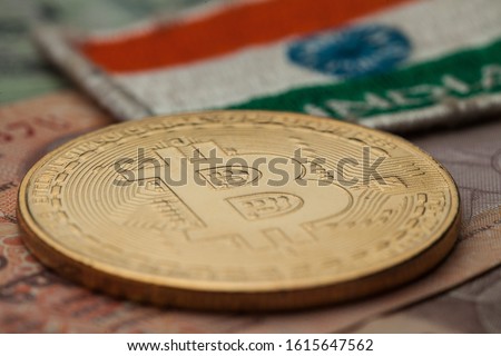 Bitcoin crypto currency coin system, golden bitcoin coin on Indian rupee banknote with India flag in background Royalty-Free Stock Photo #1615647562