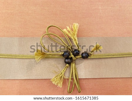 Decorative golden bow with golden rope on gift box.