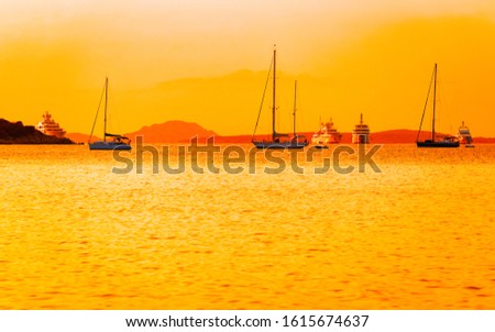 Sunrise or sunset with yachts at Porto Rotondo on Costa Smeralda at Mediterranean sea in Sardinia island of Italy. Boat in Sardegna in summer. Landscape of Olbia province. Mixed media.
