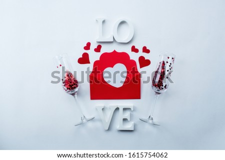 Champagne glasses, love letter and word love on a white background top view. Valentine's day background.