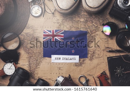 New Zealand Flag Between Traveler's Accessories on Old Vintage Map. Overhead Shot