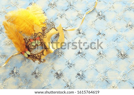 Gold elegant traditional venetian mask over vintage wooden background