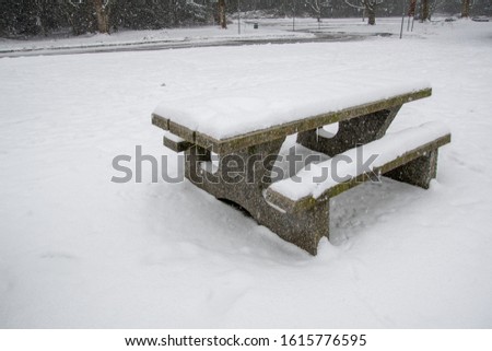 A picture of the snow-covered picnic table on the ground.   Burnaby BC Canada
