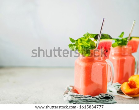 Freshly Blended Watermelon and Peach Smoothies in mason jar and metal straw. Copy space for text or design. Royalty-Free Stock Photo #1615834777