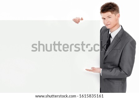 successful young businessman looking at blank banner