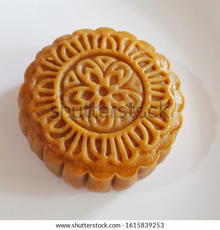 This is a traditional mid autumn snack. Food photography, side view Closeup picture of a baked moon cake on a white plate.