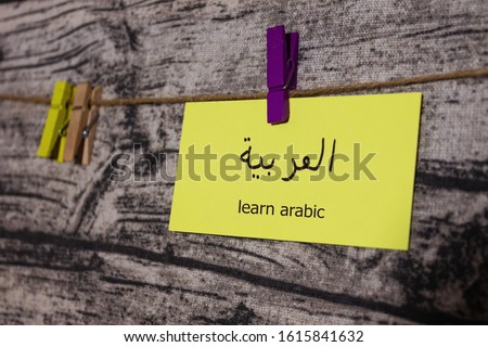 Learning arabic. Bright card on a wooden background. Card for learning a language. Clothespins on a rope. Concept