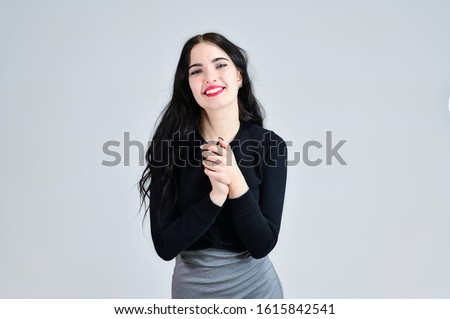 Concept of business female photo portrait with emotions. Portrait of a brunette girl with a smile with long hair with excellent makeup in a gray dress on a white background in different poses.