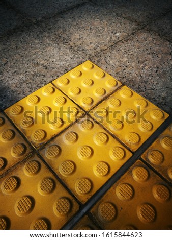 top view rubber yellow braille brick floor surface texture on marble tile background