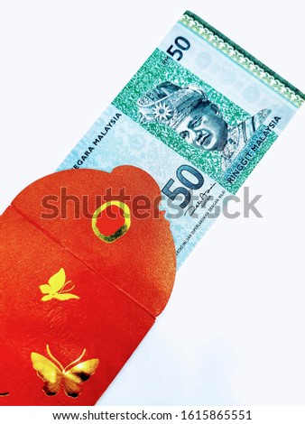 Selective focus on red packet with Malaysia money in it for the celebration of  Chinese New Year. Isolated on white background.