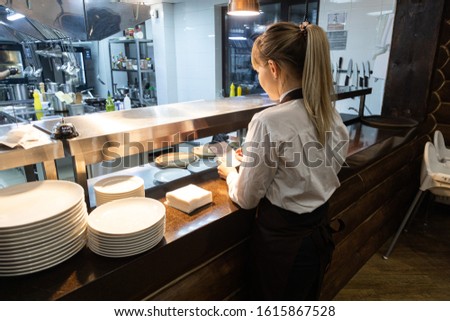 Waiters pick up ready meals in a restaurant at the counter for dispensing dishes Royalty-Free Stock Photo #1615867528